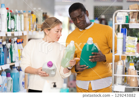 Couple man and woman choosing detergent in store 129243882