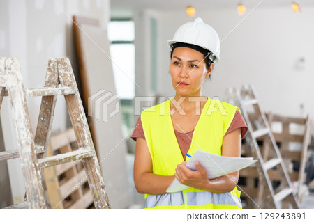 Woman engineer checking documents during repair works 129243891