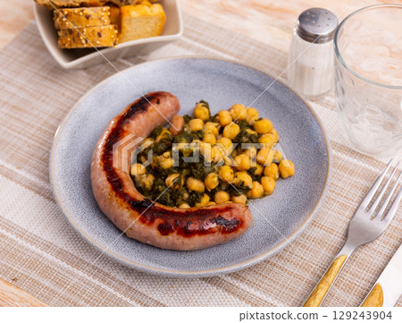 Delicious lunch from sausages, chickpeas with spinach Delicious lunch from sausages, chickpeas with spinach 129243904
