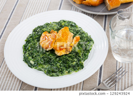 Baked chicken fillet with spinach stewed in bechamel sauce Baked chicken fillet with spinach stewed in bechamel sauce 129243924