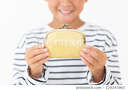 Elementary school boy holding a yellow clasp wallet Elementary school boy holding a yellow clasp wallet 129243963