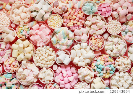 Confectionery and sweeties varieties background: light pink and white marshmallows, sugar confetti and candies, selective focus Confectionery and sweeties varieties background: light pink and white marshmallows, sugar confetti and candies, selective focus 129243994