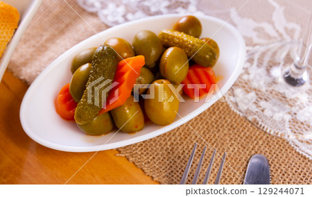 Light snack - oval bowl with pickled cucumber, carrot and green olives Light snack - oval bowl with pickled cucumber, carrot and green olives 129244071