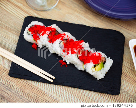 Sushi roll uramaki - tobiko roll with salmon, avocado, pepino, tobiko 129244176