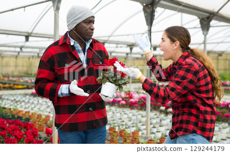 Young woman emotionally discusses work issues with an african american man colleague 129244179