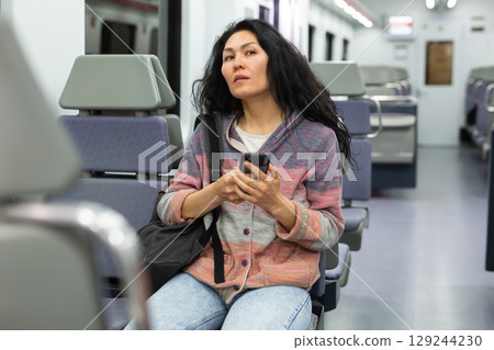 Portrait of asian woman traveler with backpack and suitcase in subway car Portrait of asian woman traveler with backpack and suitcase in subway car 129244230
