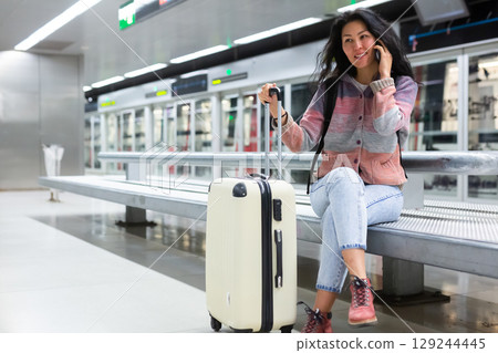 Female passenger waiting train at subway station 129244445