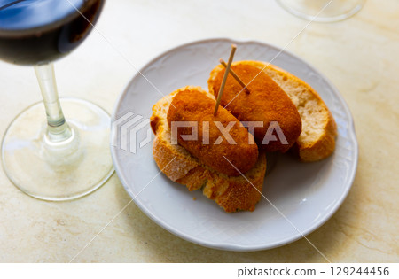 Hearty homemade food - crispy cutlets cooked in breadcrumbs, complemented with piece of bread. Hearty homemade food - crispy cutlets cooked in breadcrumbs, complemented with piece of bread. 129244456