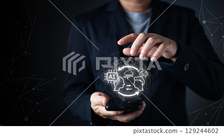 person interacts with a smartphone,projecting a glow AI digital interface.futuristic features artificial intelligence,cloud computing, and machine learning icons,symbol advanced tech and intelligence. person interacts with a smartphone,projecting a glow AI digital interface.futuristic features artificial intelligence,cloud computing, and machine learning icons,symbol advanced tech and intelligence. 129244602