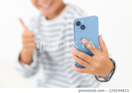 Elementary school boy taking a selfie with a smartphone 129244623