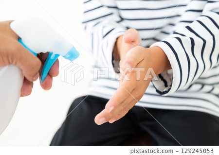 Elementary school boy using alcohol disinfectant 129245053