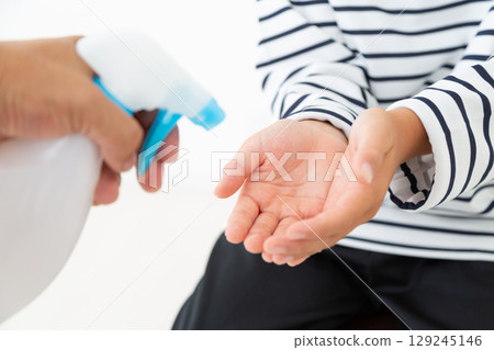 Elementary school boy using alcohol disinfectant 129245146