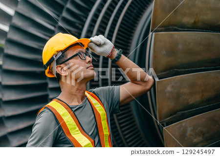 Professional Asian engineer male working service power plant turbine fan blade electrical generator Professional Asian engineer male working service power plant turbine fan blade electrical generator 129245497