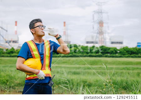 Engineer male Asian worker drinking clean water while working outdoor, Thirsty dry refreshing drink 129245511