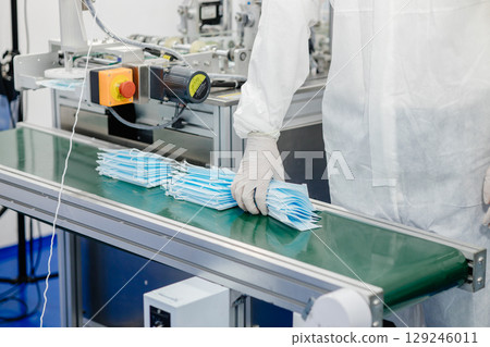 Face mask, Surgical mask production line, Closeup machine conveyor belt roller in hygiene factory 129246011