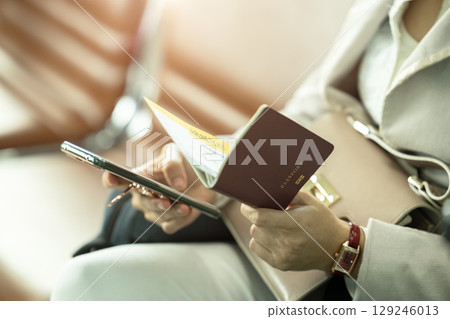 business women using smartphone application self check in with ticket boarding pass and passport 129246013