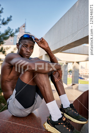 Young athlete resting outdoors during a sunny day Young athlete resting outdoors during a sunny day 129246071
