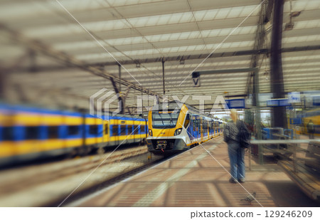 Yellow and blue NS train on the platform of Rotterdam Central Station with passengers Yellow and blue NS train on the platform of Rotterdam Central Station with passengers 129246209