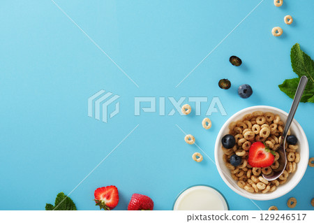 Banner with cereal flakes, milk, strawberries, blueberries, and mint on a blue background. Place for your text 129246517