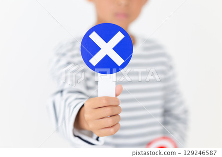 Elementary school boy holding a plate with a "X" Elementary school boy holding a plate with a "X" 129246587
