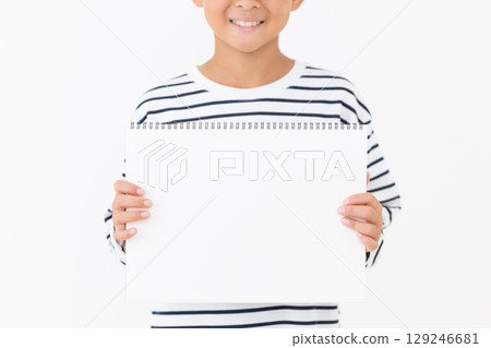 Smiling elementary school boy holding a sketchbook 129246681