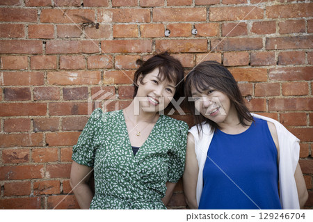 一名女子站在一棟磚造建築前 129246704