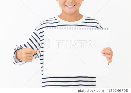 Smiling elementary school boy holding a sketchbook 129246708