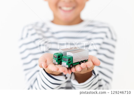 Smiling elementary school boy holding a model truck 129246710