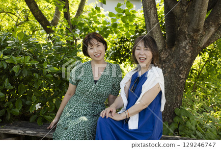 Two women relaxing in the park 129246747