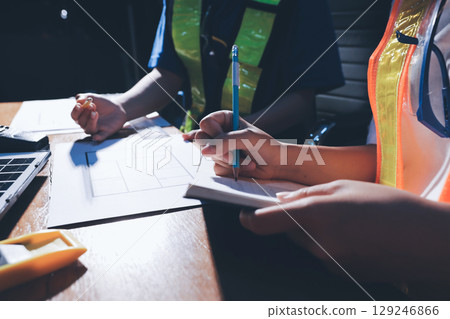 Closeup of team of industrial engineers meeting analyze machinery blueprints consult project on table in manufacturing factory. Working in manufacturing plant or production plant. Closeup of team of industrial engineers meeting analyze machinery blueprints consult project on table in manufacturing factory. Working in manufacturing plant or production plant. 129246866