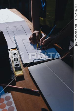 Closeup of team of industrial engineers meeting analyze machinery blueprints consult project on table in manufacturing factory. Working in manufacturing plant or production plant. 129246915