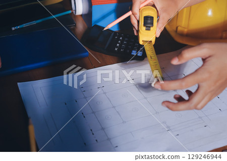 Closeup of team of industrial engineers meeting analyze machinery blueprints consult project on table in manufacturing factory. Working in manufacturing plant or production plant. 129246944
