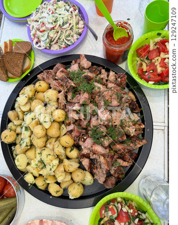 Set dining table with potatoes, kebabs salads Set dining table with potatoes, kebabs salads 129247109