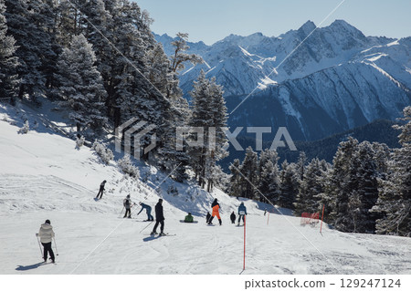 Snowboarders and skiers ski in the resort on the slopes Snowboarders and skiers ski in the resort on the slopes 129247124