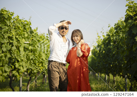 A couple walking through a vineyard A couple walking through a vineyard 129247164