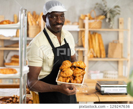 Portrait of joyful man baker with croissants Portrait of joyful man baker with croissants 129247636