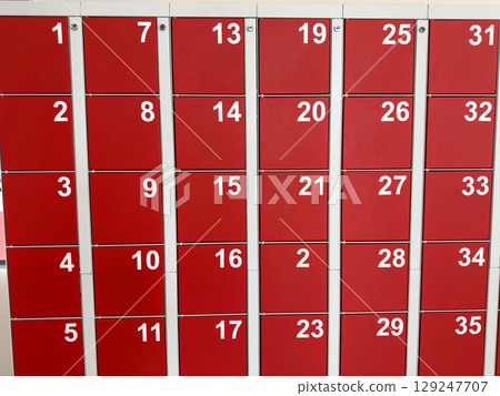 Red lockers with white numbers arranged in rows. A clear and simple design for personal storage, with numbered slots for easy identification 129247707