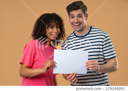 Interracial Couple Holding White A4 Paper Poster. Copy Space. Mock-up Adds Interracial Couple Holding White A4 Paper Poster. Copy Space. Mock-up Adds 129248091