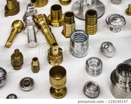 Variety of metal components in different finishes arranged on a work surface for inspection and analysis 129248147