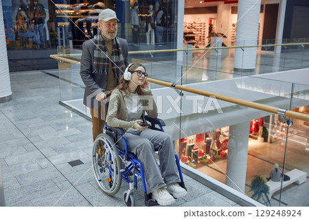 Granddad and his granddaughter who uses a wheelchair sharing lovely moment together 129248924