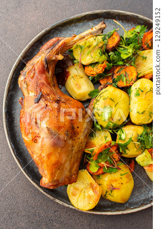 Baked rabbit with potatoes and carrots, a set table with food Baked rabbit with potatoes and carrots, a set table with food 129249152