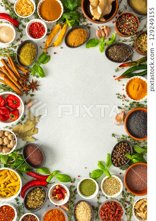 A lively frame of assorted herbs and spices on gray, highlighting the vibrant colors and flavors for cooking inspiration, top view and copy space A lively frame of assorted herbs and spices on gray, highlighting the vibrant colors and flavors for cooking inspiration, top view and copy space 129249155