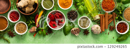 A beautiful collection of colorful spices and herbs, showcasing their natural aromas and vibrant hues on a gentle green background, top view , banner A beautiful collection of colorful spices and herbs, showcasing their natural aromas and vibrant hues on a gentle green background, top view , banner 129249265