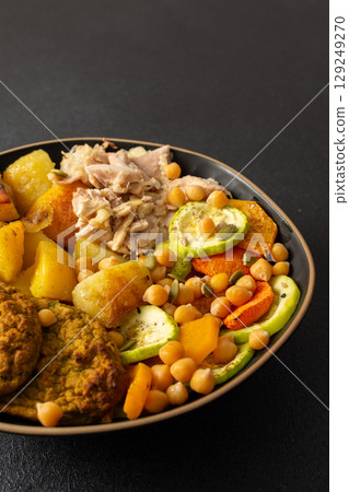 A hearty breakfast features baked sweet potato with carrots and zucchini, chicken breast, lentil cutlets, and kiwi for dessert perfect for a nutritious start A hearty breakfast features baked sweet potato with carrots and zucchini, chicken breast, lentil cutlets, and kiwi for dessert perfect for a nutritious start 129249270