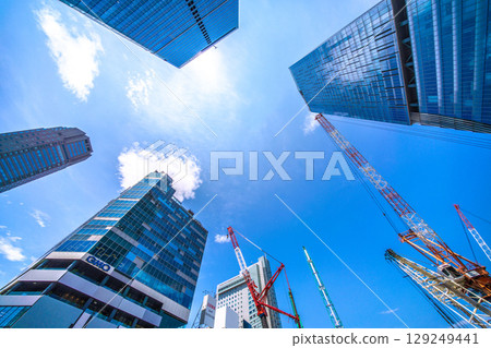 Tokyo cityscape, Japan, August 5th. Extremely hot... Huge heavy machinery such as piledrivers lined up... Towards a new chapter... = Shibuya 129249441