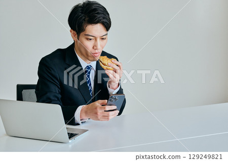 Young man eating a hamburger for lunch 129249821