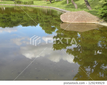 Blue sky and white clouds reflected in Hamanoike Pond in Inage Seaside Park Blue sky and white clouds reflected in Hamanoike Pond in Inage Seaside Park 129249929