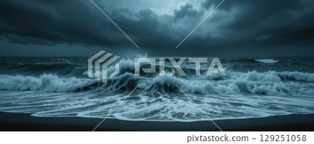 A stormy day on a dark beach with crashing waves 129251058