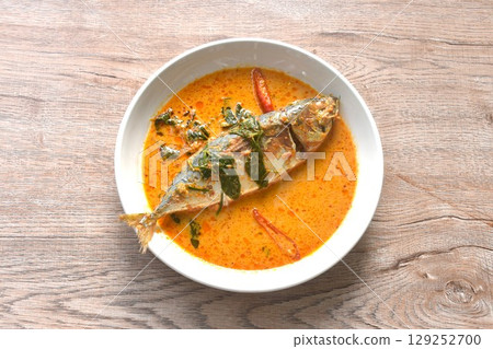 spicy boiled mackerel topping chop lemon grass in red curry sauce on plate  129252700