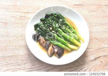 fried Kailaan Chinese kale and black mushroom dressing oyster sauce with chop garlic on plate 129252706